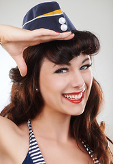 Image showing Travel, portrait and salute of a sailor, woman and model in studio isolated on a white background. Smile, pin up and face of vintage air hostess in hat, makeup and pinup girl in Spain for fashion