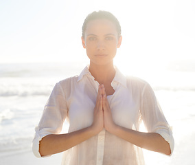 Image showing Portrait, yoga and meditation with woman on beach at sunset for wellness, balance or inner peace. Summer, nature and zen with serious young person by sea or ocean for health, awareness or mindfulness