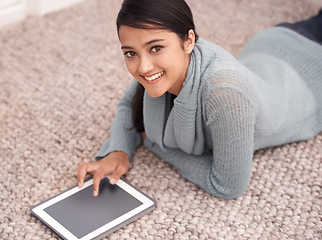 Image showing Portrait of happy woman on floor with tablet, relax and smile with studying, research and social media in house. Student girl on carpet with digital app, elearning and checking blog online in home.