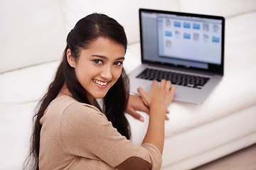 Image showing Portrait, home and woman with a laptop, connection and typing in a living room, digital app and internet. Face, person or girl in a lounge, technology and website with daily news, computer and happy