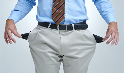 Image showing Businessperson, empty pocket and poor in studio, unemployment and bankruptcy by white background. Closeup, no money and financial trouble or bad investment, stock market crash and debt or broke