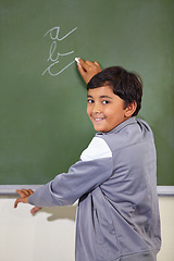 Image showing Portrait, chalkboard and boy drawing, happy or child development with confidence, joy or art for learning. Academic, creative or kid student writing for practice in the classroom with face or cursive