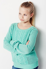 Image showing Child, relaxing and fashion pride in studio, cool and confidence by white background. Female person, girl and casual clothing or style by backdrop, kid and trendy winter sweater or arms crossed