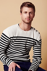 Image showing Fashion, aesthetic and portrait of man on beige background in trendy, stylish and casual clothes. Confidence, attractive and person with stripe style for positive attitude, pride and model in studio