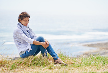 Image showing Woman, thinking and relax in nature at beach with happiness, gratitude and peace on holiday or vacation. Ocean, mock up and person on hill at the sea with ideas for future, travel and environment