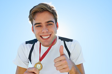 Image showing Athlete, man and thumbs up with medal for sports achievement, success portrait and yes in competition. Face of winner or runner with like, smile or good job hands, emoji and gold award on a blue sky