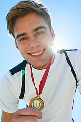 Image showing Winner, man and sports medal for achievement, success and portrait in running competition. Happy face of a runner or athlete with red and gold prize, contest or marathon on a blue sky and lens flare