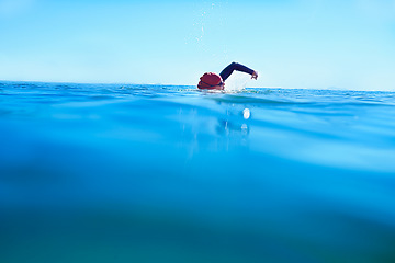 Image showing Swimming, stroke and person in sea water in summer for exercise, training or workout on mockup space. Ocean, sport and a athlete crawl outdoor for fitness, health and triathlon competition in nature