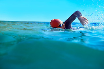 Image showing Swimming, crawl and person in ocean water in summer for exercise, training or workout on mockup space. Sea, sport and a young athlete outdoor for fitness, health and triathlon competition in nature