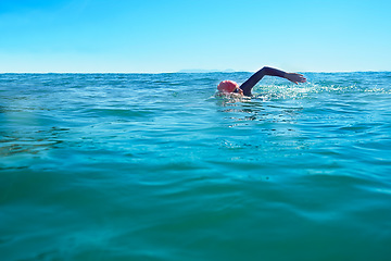 Image showing Swimming, stroke and person in ocean water in summer for exercise, training or workout on mockup space. Sea, sport and a young athlete outdoor for fitness, health and triathlon competition in nature