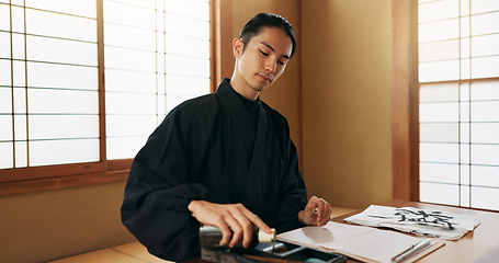 Image showing Black ink, Asian man or Japanese artist in studio for art and script, calligraphy with paper for alphabet. Start, ready or creative person with tools, paintbrush and focus with traditional stationery