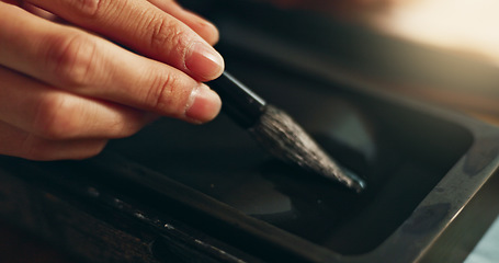 Image showing Hand, closeup of brush in ink for writing and calligraphy or ancient stationery for art and inkstone. Japanese creativity, black paint with paintbrush and person stroke with traditional vintage tools