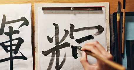 Image showing Man, calligraphy or hands of a Japanese artist in studio for art and script, letter with closeup for alphabet. Start, top or male person with tools, paintbrush and focus with traditional stationery