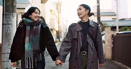 Image showing Couple, smile and holding hands for walking in city, street and conversation with travel, vacation and care. Man, woman and together with chat, support and love on holiday on metro sidewalk in Tokyo