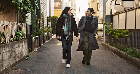 Image showing Couple, happy and meeting on walk in city, street and conversation with travel, vacation and care. Man, woman and together with chat, support and love on holiday on metro sidewalk in Tokyo