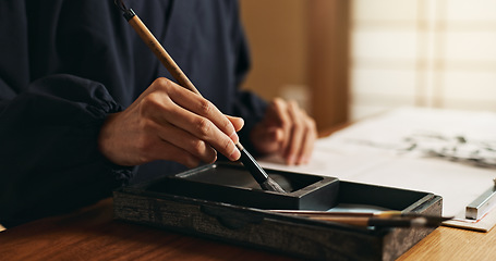 Image showing Hands, brush in ink for writing and Japanese calligraphy or ancient script for art and inkstone. Asian creativity, black paint and vintage tools, paintbrush and person with traditional stationery