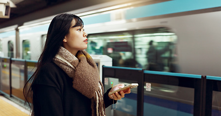 Image showing Japanese woman, phone and train station for travel with app, waiting and happy for metro transportation. Girl, smartphone and happy for commute with locomotive for journey, adventure or web in Tokyo