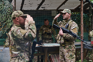 Image showing A dedicated soldier salutes his elite unit, showcasing camaraderie and readiness for the most perilous military operations