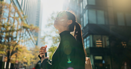 Image showing Japanese woman, phone and earphones in city with smile, walking and listening to music by buildings. Person, pedestrian and smartphone with audio streaming subscription with radio app on metro street