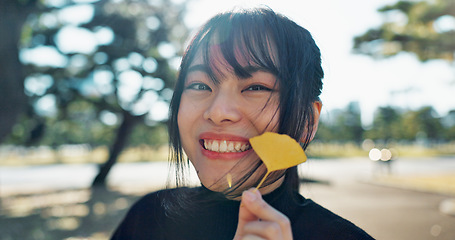 Image showing Asian, happy woman in park and leaf with face and explore nature for wellness and outdoor environment. Sunshine, plants and portrait, travel and adventure in public garden with smile on journey