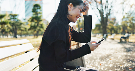 Image showing Japanese woman, bench and smartphone in park with relax, happiness and social media in sunshine in city. Female person, sitting and wellness with cellphone in town, streaming and digital technology