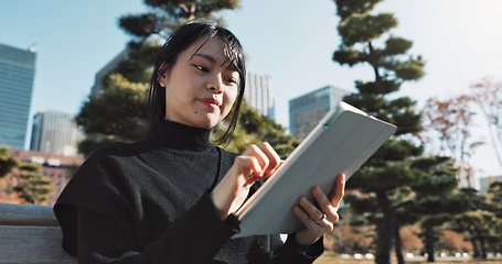 Image showing Happy asian woman, tablet and research at park in city for social media or outdoor networking. Female person smile with technology in relax for online search, reading or communication in nature
