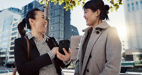 Image showing Phone, laughing and Japanese business woman in city together for travel, journey or commute. Collaboration, planning and funny with employee friends reading text message for discussion in Tokyo