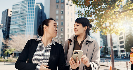 Image showing Phone, smile and Japanese business woman in city together for travel, journey or commute. Collaboration, planning and discussion with happy employee team reading text message outdoor in Tokyo