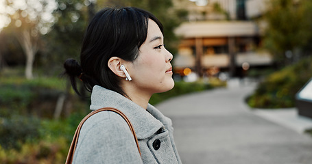Image showing Japanese woman, earphones and walk in street with listening, music and streaming subscription in city. Business person, audio tech and sound for podcast, radio and travel on metro sidewalk in Tokyo