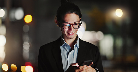 Image showing Businessman, cellphone and typing in city at night for company travel opportunity, accomplishment or employment. Asian person, smile and texting in urban Japan as lawyer or communication for work