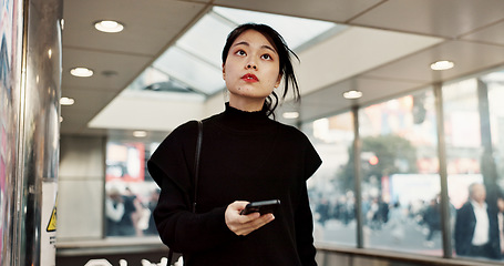 Image showing Phone, subway and a Japanese woman in city on social media, networking and notification in Tokyo. Smartphone, girl and serious person on mobile communication technology, thinking and internet app