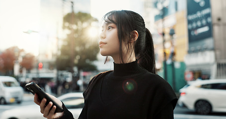 Image showing Walking, cellphone and Japanese woman in the city networking on social media or the internet. Phone, adventure and young female person commuting for travel in road of urban town in Kyoto Japan.