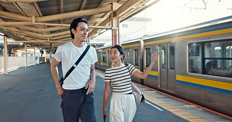 Image showing Walking, conversation and young couple by train station for exploring on vacation or holiday. Travel, happy and Asian man and woman talking by public transport for adventure together on weekend trip.