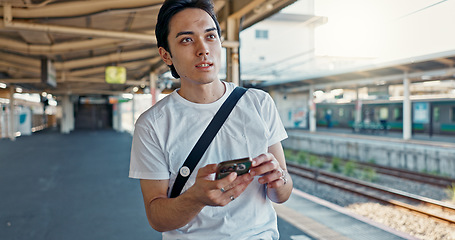 Image showing Man, check phone and waiting at train station with reading, thinking and location with digital schedule. Man, travel and smartphone for transportation app, time management or map for tourism in Japan