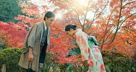 Image showing People in park in Japan, bow and traditional clothes with hello, nature and sunshine with respect and culture. Couple outdoor together in garden, greeting with modesty and tradition, polite and kind