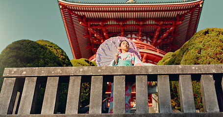 Image showing Japanese woman, umbrella and shinto temple with traditional clothes, culture and religion in sunshine. Person, girl and parasol for walk with faith, mindfulness and thinking with low angle in Kyoto