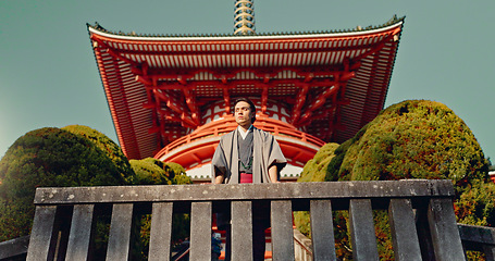 Image showing Man, Japanese shinto temple and traditional clothes for culture, building or religion in sunshine. Person, ideas and vision for perspective with faith, mindfulness or thinking with low angle in Kyoto