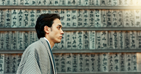 Image showing Outdoor, walking and wall with man, Japan and calligraphy with peace, choice and thinking. Person, calming and guy with traditional clothes, travel and decision with thoughts, wonder and aesthetic