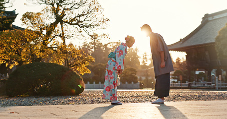 Image showing Japanese people at temple, bow and traditional clothes with hello, nature and sunshine with respect and culture. Couple outdoor, greeting with modesty and tradition, polite and kind for religion