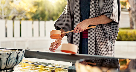 Image showing Shinto temple, person and wash hands at fountain, container or cleaning for worship with faith. Religion, mindfulness and purification ritual to stop evil, bacteria or splash ladle at shrine in Tokyo