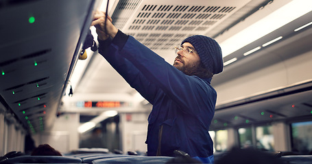 Image showing Man, train travel and overhead luggage compartment for storage, safety and property with thinking. Person, guy and baggage in container for commute with railway infrastructure on holiday in Tokyo