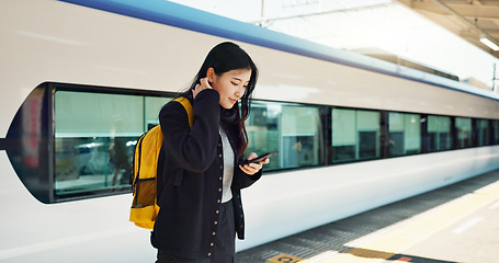 Image showing Asian woman, phone and train for social media, travel or communication at railway station. Female person smile with backpack or bag on mobile smartphone waiting for transportation, trip or traveling