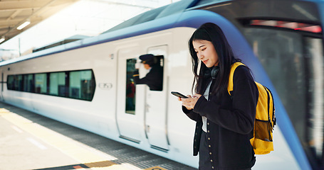 Image showing Asian woman, phone and train for travel, communication or social media at railway station. Female person smile with backpack or bag on mobile smartphone waiting for transportation, trip or traveling