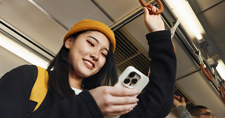 Image showing Japanese woman, phone and texting in train, smile and travel with click, press and check schedule on app. Girl, person and smartphone with chat, reading blog and social network with public transport