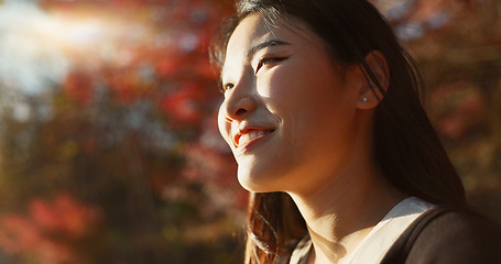 Image showing Outdoor, thinking and Asian woman with a smile, nature and forest with joy, daydreaming and holiday. Japanese person sunshine or girl with summer, travel or peace with vacation. calm or weekend break