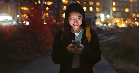 Image showing Asian woman, phone and night for communication, social media or outdoor networking in city. Female person walking with mobile smartphone in late evening for online chatting in urban town of Japan