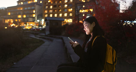 Image showing Asian woman, phone and night at city for social media, communication or outdoor networking. Female person relax on mobile smartphone in the late evening for online chatting in urban town of Japan