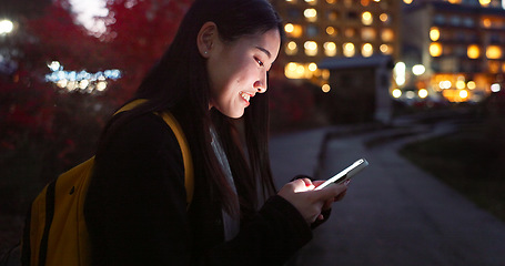 Image showing Asian woman, phone and night at city for social media, communication or outdoor networking. Female person relax on mobile smartphone in the late evening for online chatting in urban town of Japan