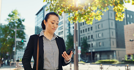 Image showing Cellphone, walking and business woman in the city networking on social media, mobile app or internet. Technology, street and professional Asian female person with phone commuting in street in town.