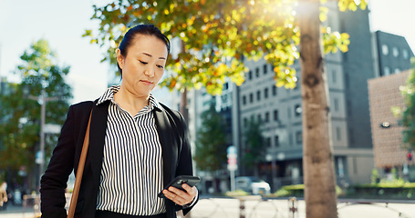 Image showing Cellphone, walking and business woman in the city networking on social media, mobile app or internet. Technology, street and professional Asian female person with phone commuting in street in town.